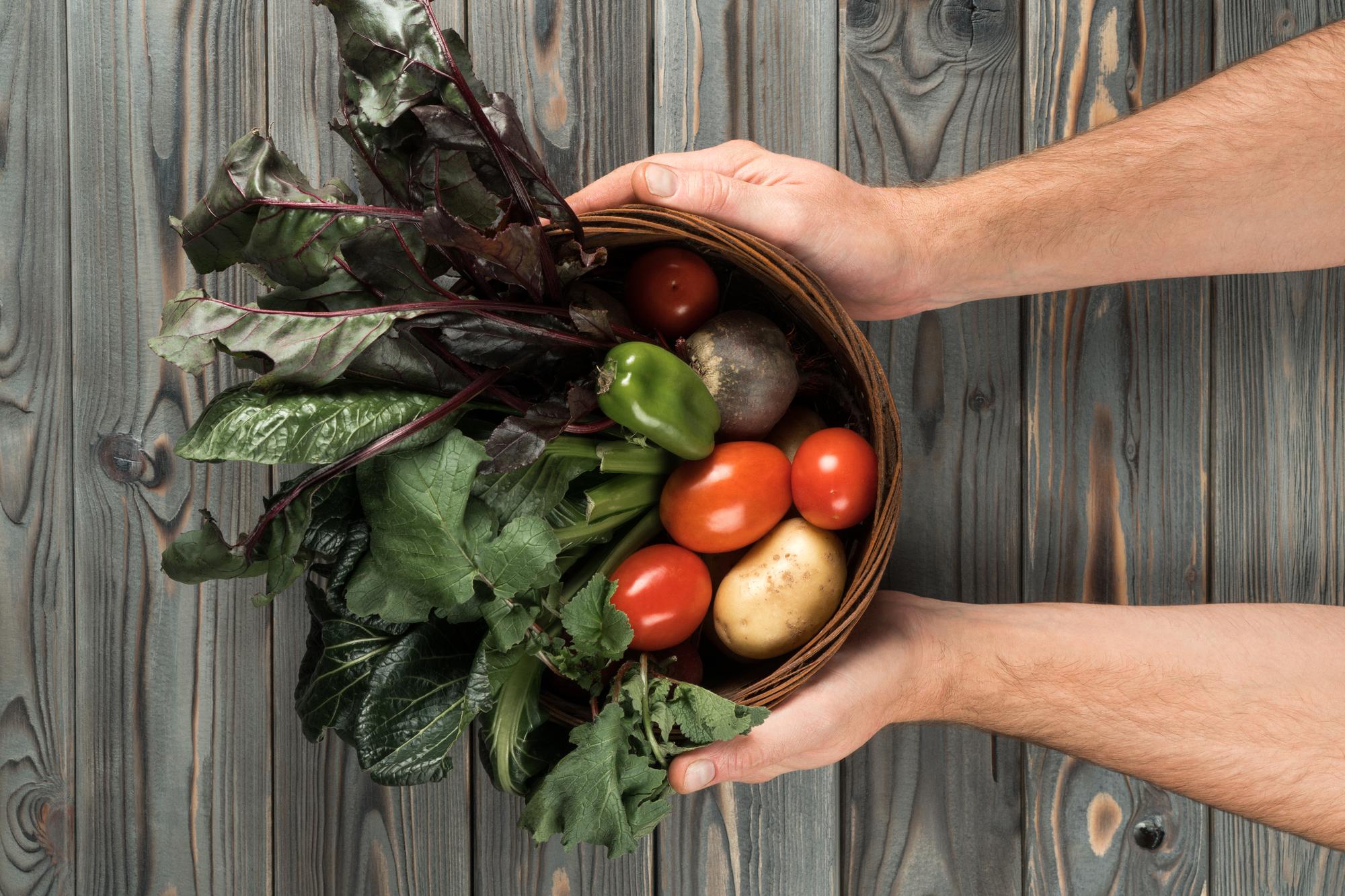 hands selecting seasonal vegetables in a sunlit market