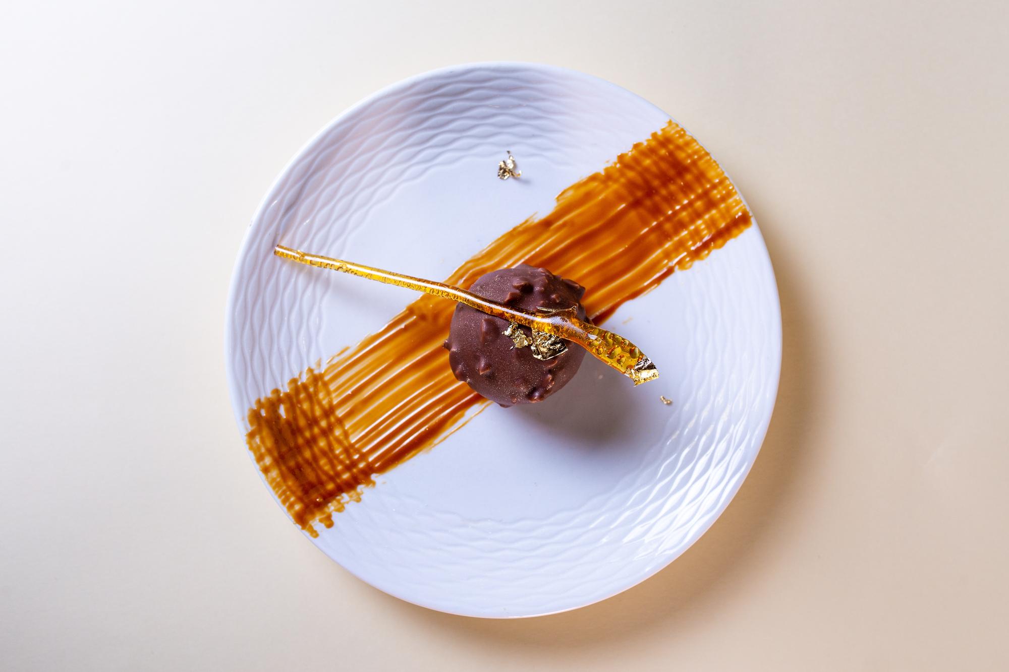 overhead of composed dessert with gold leaf