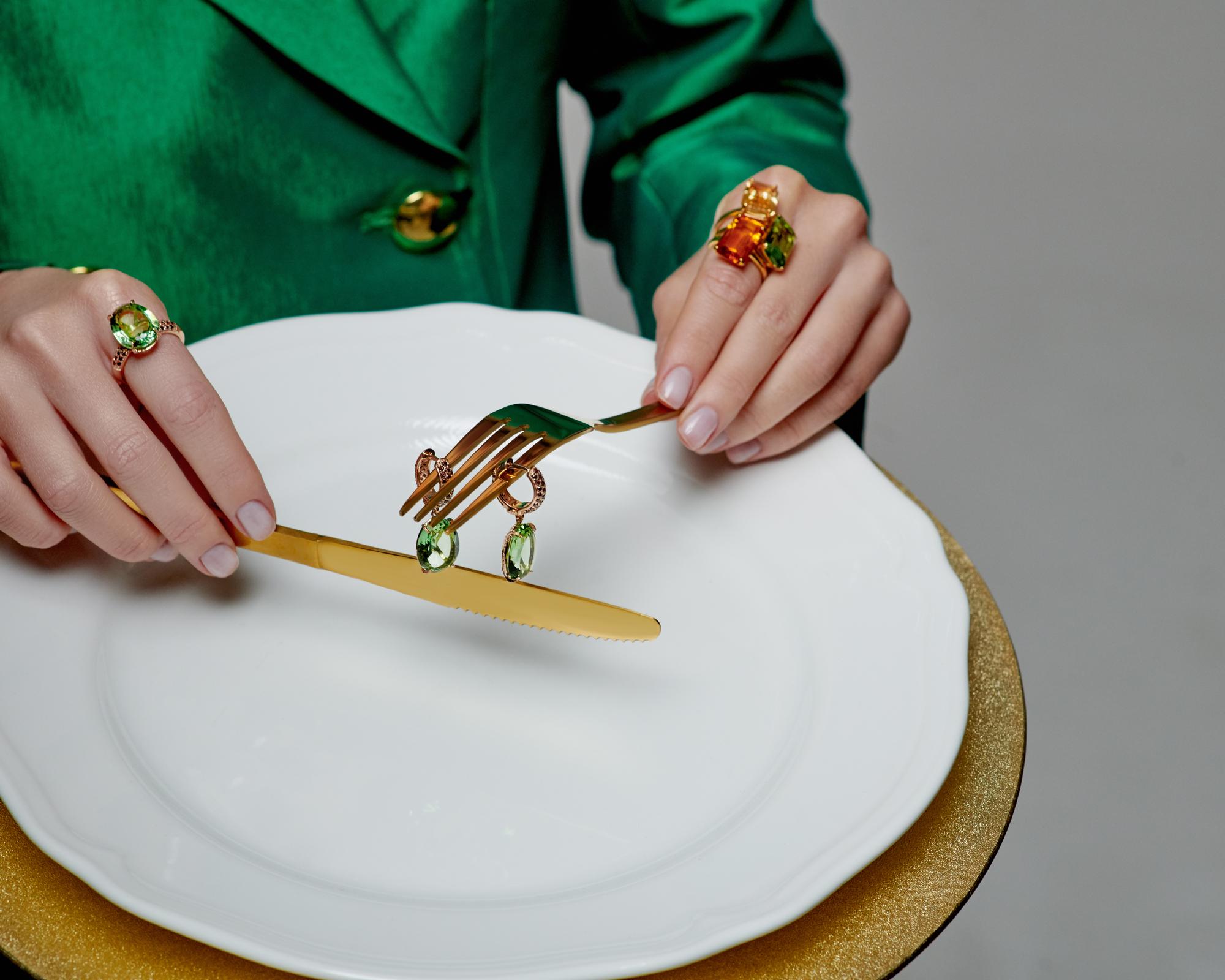chef plating a refined dish on a white plate with gold accents